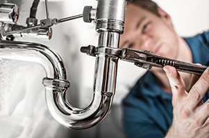 Plumber fixing pipes during plumbing services